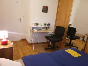 a room with a desk and two chairs and a bed at Cozy Private Room -5 mins from CERN -Shared Apartment in Saint-Genis-Pouilly