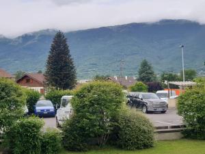 a parking lot with cars parked in front of a mountain at Cozy Private Room -5 mins from CERN -Shared Apartment in Saint-Genis-Pouilly