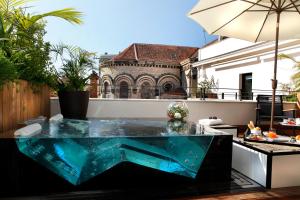 a glass table on top of a balcony at Five Seas Hotel Cannes, a Member of Design Hotels in Cannes