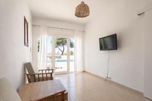 a living room with a table and a tv on the wall at V110B Villa La Pau in Son Bou