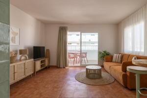 a living room with a couch and a tv at The Loft House Ibiza in Santa Eularia des Riu