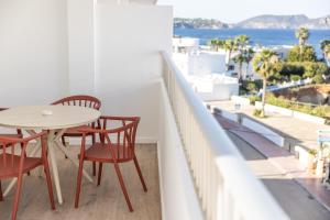 a table and chairs on a balcony with a view of the ocean at The Loft House Ibiza in Santa Eularia des Riu