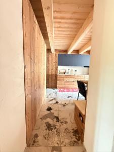 a kitchen with wooden walls and a table and a chair at Maso K - Il Gufo Dorato in Folgaria