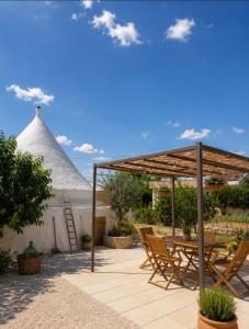 a patio with a table and chairs under a canopy at Il trullo di Mattia in Noci