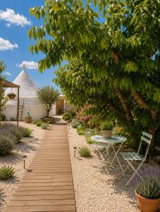 a wooden walkway in a garden with a table and a tent at Il trullo di Mattia in Noci +19 photos