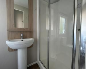 a white bathroom with a sink and a shower at Sycamore Farm Park in Burgh le Marsh +46 photos