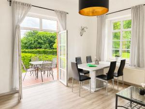 a dining room with a table and chairs and a patio at Gut Rottmannshagen Mecklenburgische Seenplatte in Jürgenstorf