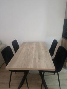 a wooden table with four chairs around it at CityLux L in Doboj