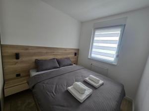 a bedroom with a bed with two towels on it at CityLux L in Doboj