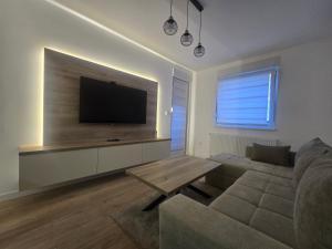 a living room with a couch and a flat screen tv at CityLux L in Doboj