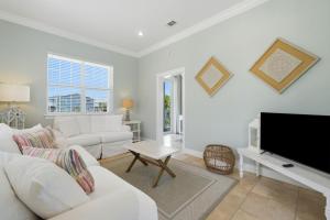 a living room with white furniture and a flat screen tv at Periwinkle Paradise in Navarre