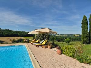 a pool with umbrellas and lounge chairs next to at LBCA maison campagnarde in Casteljaloux +22 photos