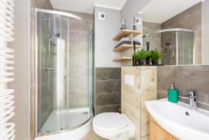 a bathroom with a shower and a toilet and a sink at HomeKoko Apartments in Katowice +105 photos
