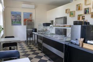 a kitchen with a counter and chairs in a room at Kolegium Nowe PANS - hostel in Przemyśl