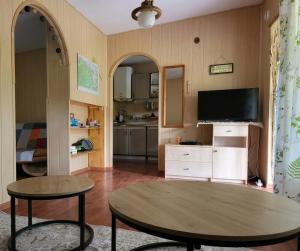 a living room with a table and a tv at Domek Ostróda in Ostróda