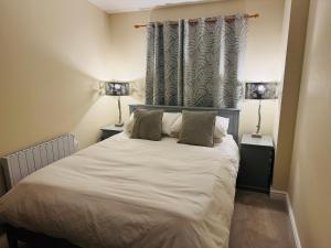 a bedroom with a large bed with two lamps at The Goods Shed in Narborough