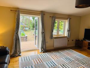 a living room with a couch and a sliding glass door at The Goods Shed in Narborough