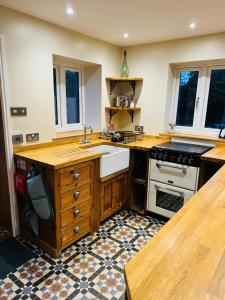 a kitchen with a sink and a stove at The Goods Shed in Narborough