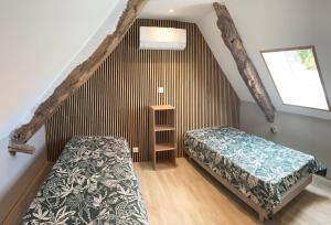 a attic bedroom with a bed and a window at Les maisons de Palis in Salvagnac-Cajarc