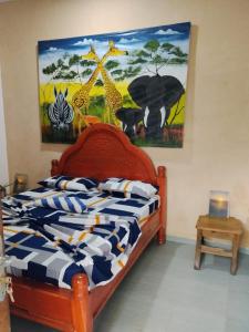 a bedroom with a bed with a painting on the wall at POLE-INN VILLA Nungwi Zanzibar in Nungwi +63 photos
