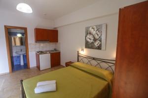 a small bedroom with a green bed and a kitchen at Villa Herkules in Olympic Beach