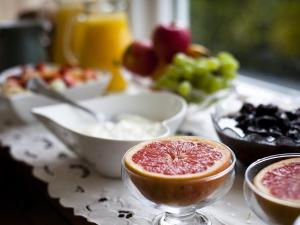 a table topped with bowls of food with a grapefruit at Y Garth B&B in Newport