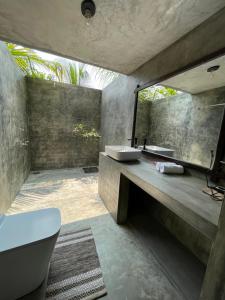 a bathroom with two sinks and a mirror at Aji fruit farm cottage peaceful lakeside farm stay with sunrise views 03 in Embilipitiya