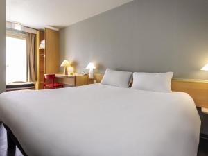 a large white bed in a hotel room at ibis Rochefort in Rochefort