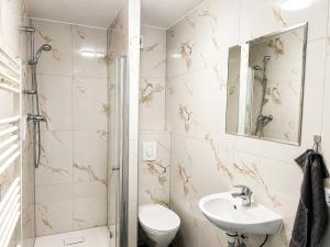 a bathroom with a sink and a toilet and a mirror at NOBLE APART Saarbrücken City Center in Saarbrücken