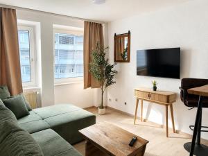 a living room with a couch and a flat screen tv at NOBLE APART Saarbrücken City Center in Saarbrücken