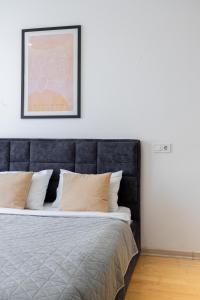 a bed with a black headboard in a room at Nyvky Like Home - Studio - apt 35 in Kyiv