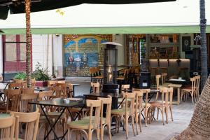 a restaurant with tables and chairs and a fireplace at Ciel Suites Athens in Athens