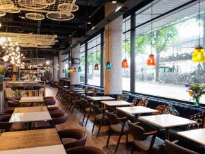 a row of tables and chairs in a restaurant at ibis Amsterdam Centre in Amsterdam