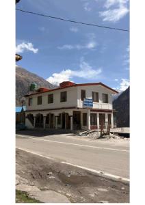 a white building on the side of a road at Ekdantam Hotel and Restaurant in Uttarkāshi +13 photos
