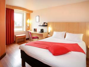 a hotel room with a large bed and a desk at ibis Toulouse Centre in Toulouse +75 photos