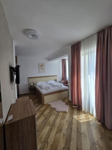 a bedroom with a bed and a wooden floor at Vila La Familia in Budžak