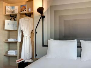 a bedroom with a bed and a dress on a rack at ibis Vichy in Vichy +27 photos