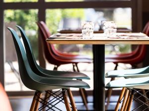 a wooden table with chairs and glasses on it at ibis Vesoul in Vesoul