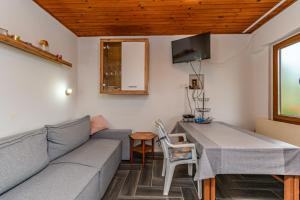 a living room with a couch and a table at Apartments Steps from the Sea in Donja Klada