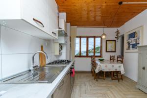 a kitchen with a sink and a table in it at Apartments Steps from the Sea in Donja Klada
