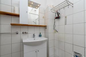 a white bathroom with a sink and a mirror at Apartments Steps from the Sea in Donja Klada +72 photos