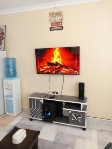 a living room with a tv on a wall at Bnb Studio Oasis Homes in Machakos