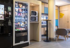 a refrigerator with drinks in it in a restaurant at B&B HOTEL Annecy Argonay in Argonay