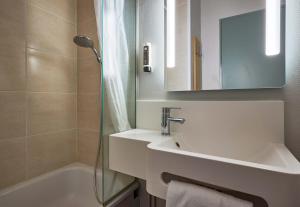 a bathroom with a sink and a shower and a mirror at B&B HOTEL AVRANCHES Baie du Mont St-Michel in Le Val-Saint-Père
