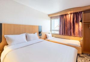 a hotel room with a large bed and a window at B&B HOTEL Lyon Eurexpo Bron in Bron