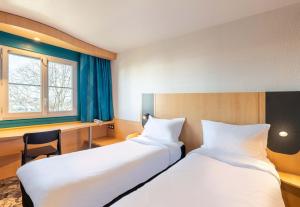 a hotel room with two beds and a window at B&B HOTEL Lyon Eurexpo Bron in Bron +23 photos