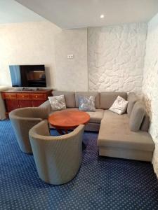 a living room with a couch and chairs and a table at Fürstenhof Wernigerode Garni in Wernigerode