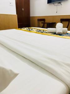 a bed with white sheets and folded towels on it at Minh Thư Phú Mỹ Hotel in Phú Mỹ