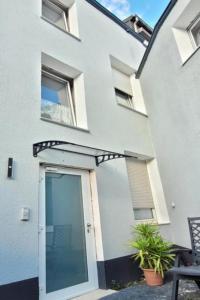 a white house with a door and a patio at Privileg - NewTime in Viersen