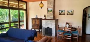 a living room with a couch and a table and a fireplace at Quarto Iucas in Teresópolis